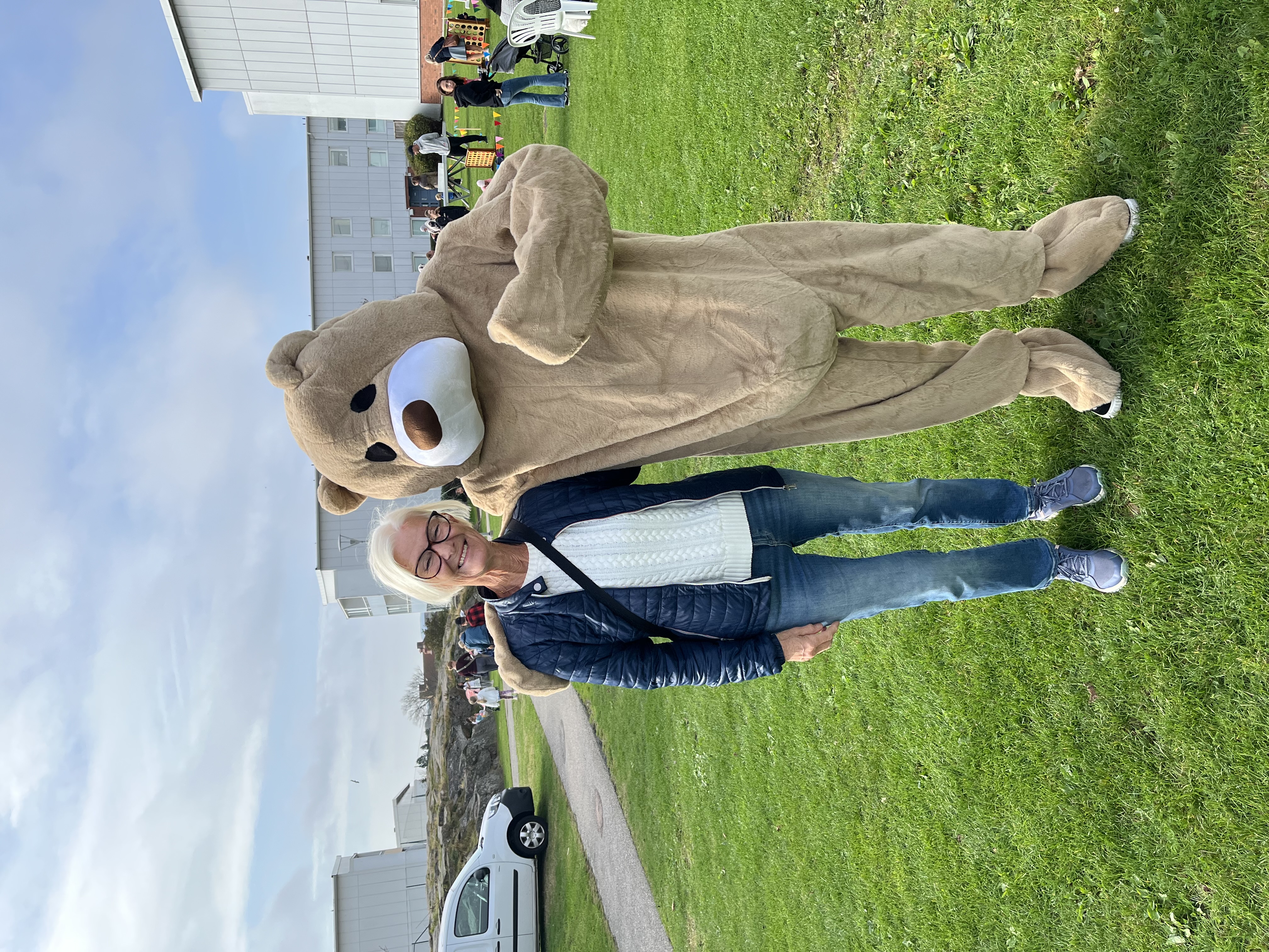 Nallebjörnen lägger armen om enn vuxen besökare