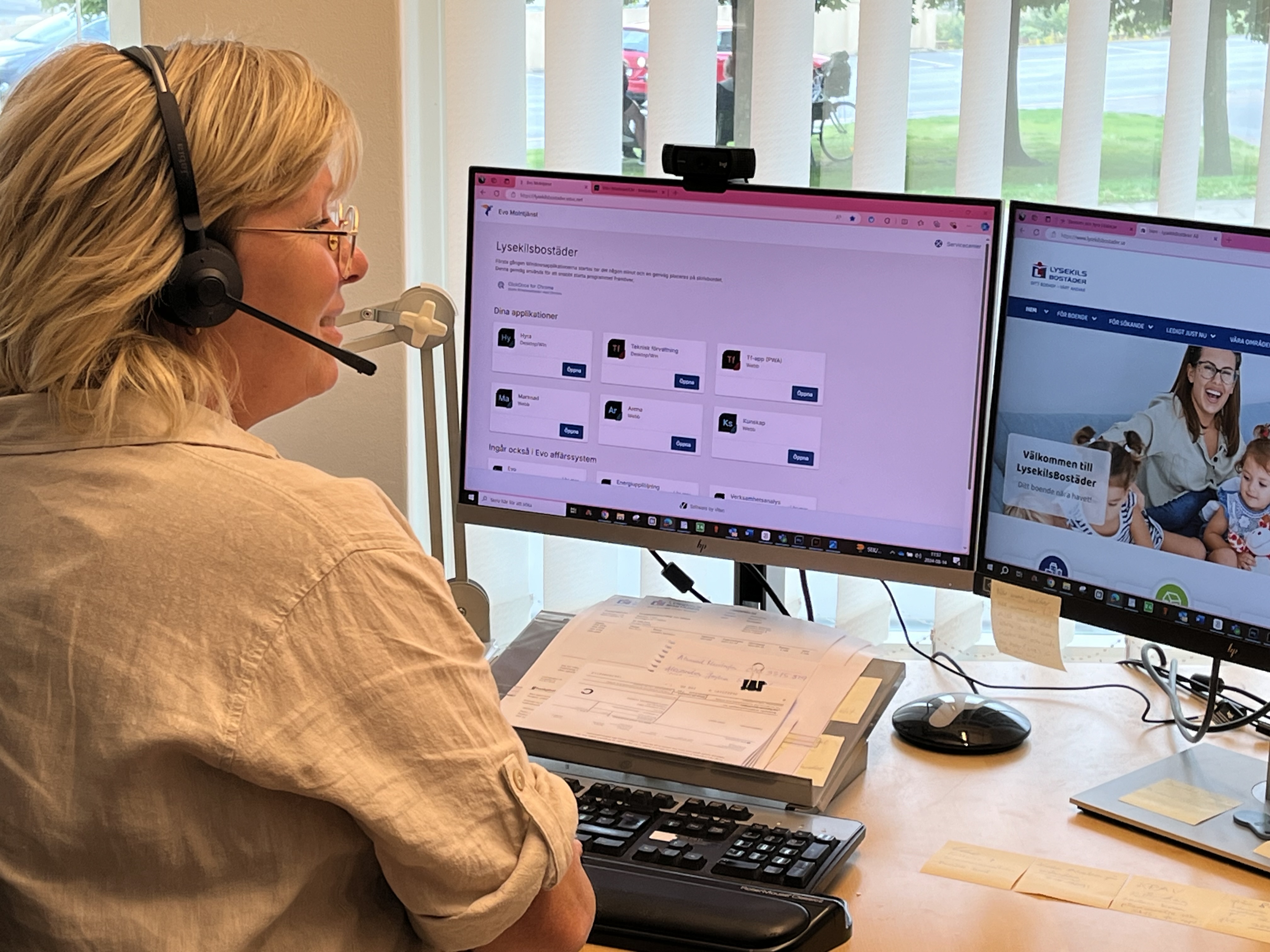 En kvinna sitter framför en dator och pratar i sitt headset.